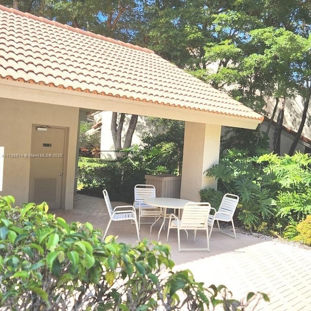 view of patio / terrace featuring visible vents, fence, outdoor dining area, and a gazebo