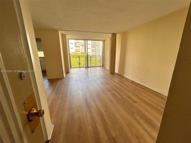 empty room with expansive windows and light wood-type flooring