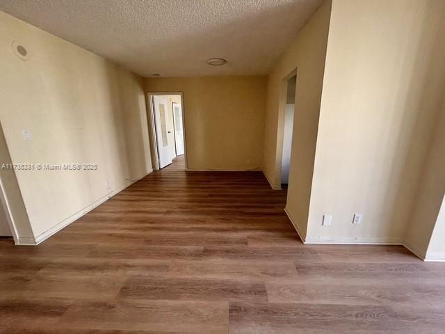 hall featuring wood-type flooring and a textured ceiling