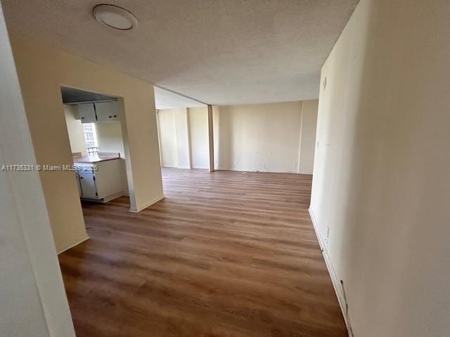 hallway with wood-type flooring and a textured ceiling