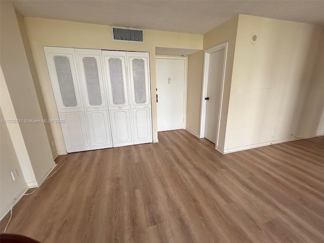 unfurnished bedroom with wood-type flooring and a closet