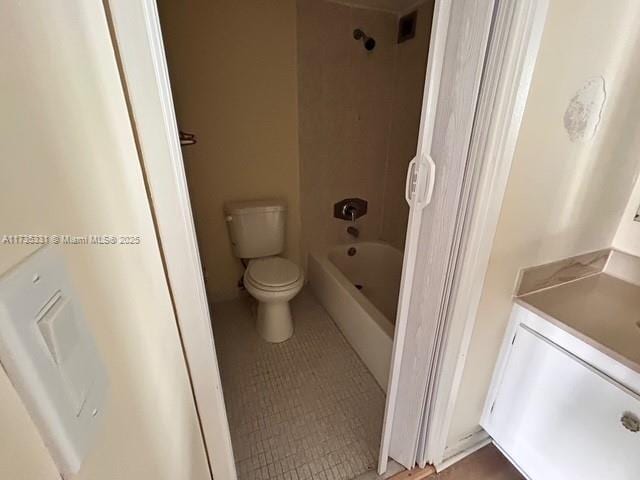 full bathroom with tiled shower / bath combo, vanity, tile patterned floors, and toilet