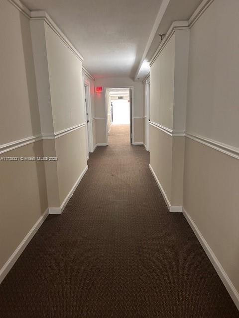 hallway featuring dark carpet