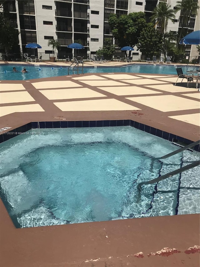 view of swimming pool featuring a hot tub