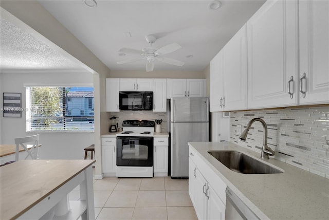 kitchen with sink, light tile patterned floors, backsplash, stainless steel appliances, and white cabinets