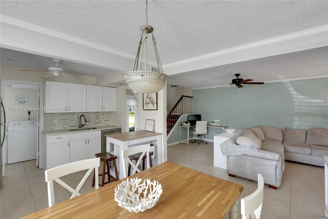 tiled dining space with ceiling fan, ornamental molding, sink, and a textured ceiling