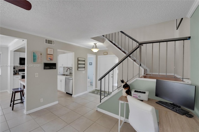 interior space featuring ornamental molding, tile patterned flooring, sink, and a textured ceiling