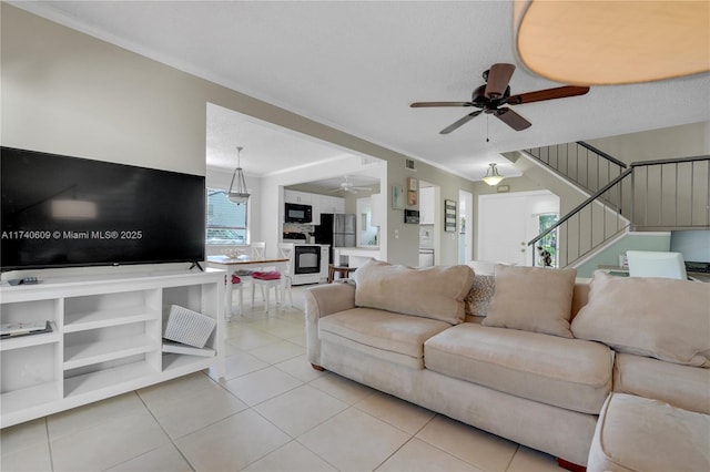 living room with light tile patterned floors, a textured ceiling, and ceiling fan