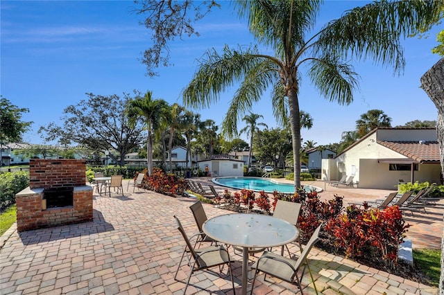 view of patio featuring a community pool and exterior kitchen