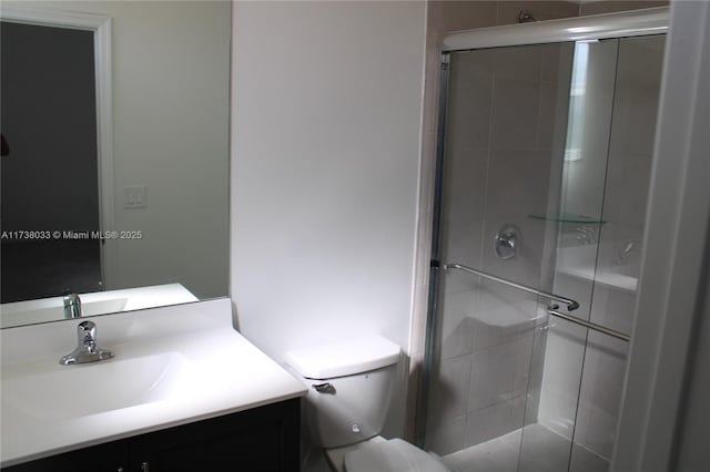 bathroom featuring vanity, an enclosed shower, and toilet