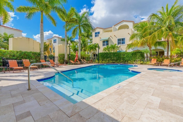 view of pool with a patio area and a hot tub