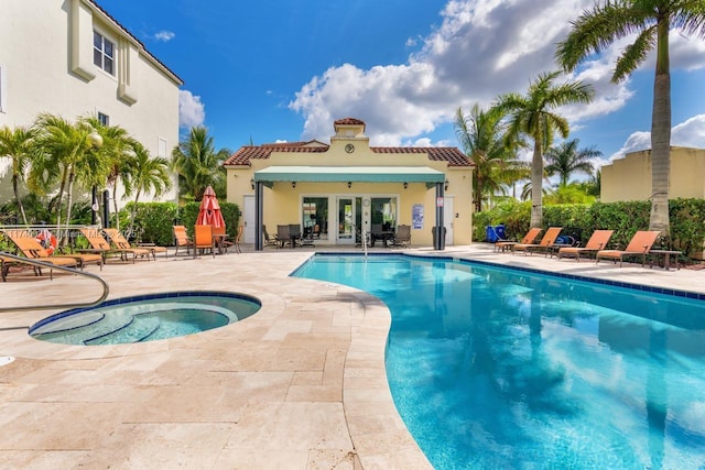 view of swimming pool featuring a hot tub and a patio