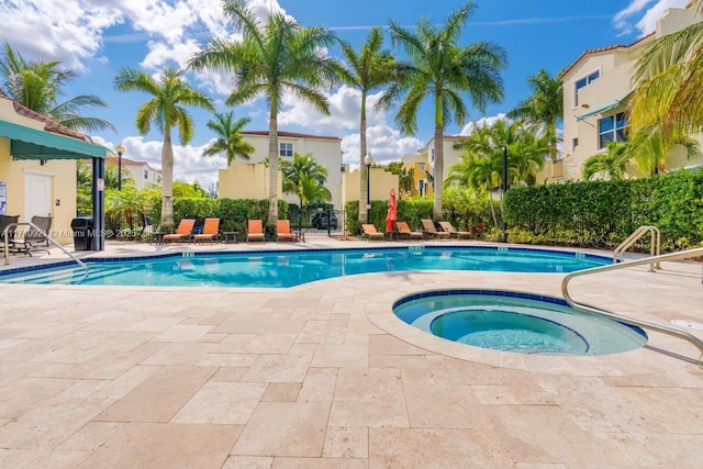 view of swimming pool with a patio and a community hot tub