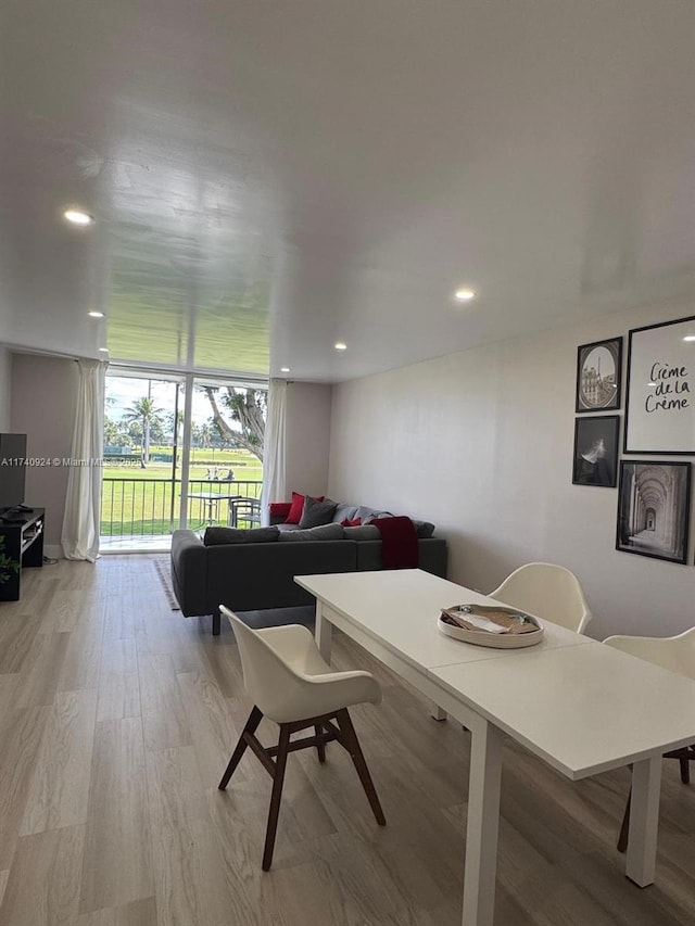 dining room with floor to ceiling windows and light hardwood / wood-style flooring