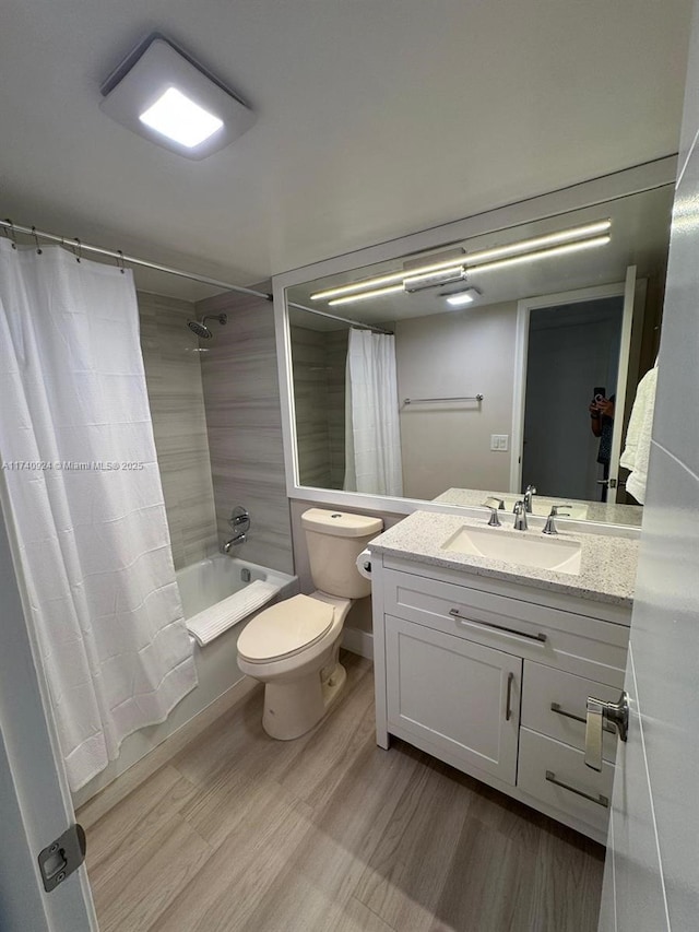 full bathroom featuring vanity, hardwood / wood-style flooring, toilet, and shower / bath combo