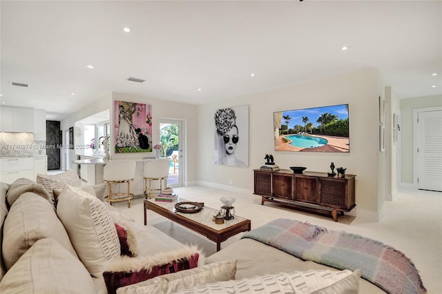 living area featuring recessed lighting, visible vents, and baseboards