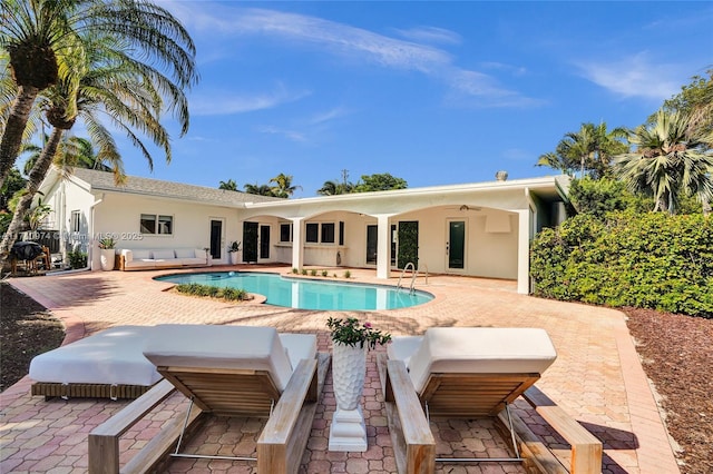 outdoor pool with a patio and a ceiling fan