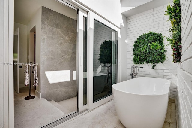 bathroom featuring tile patterned flooring and a freestanding tub