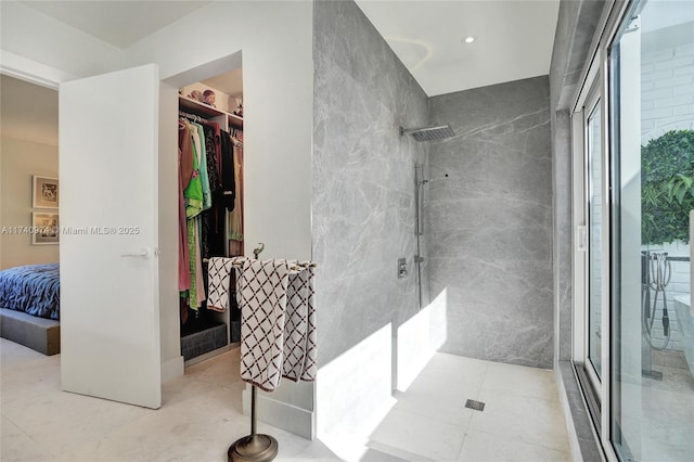 full bathroom with a spacious closet, walk in shower, and tile patterned floors