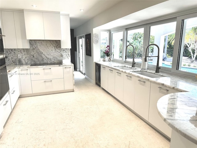 kitchen featuring modern cabinets, white cabinets, and a sink