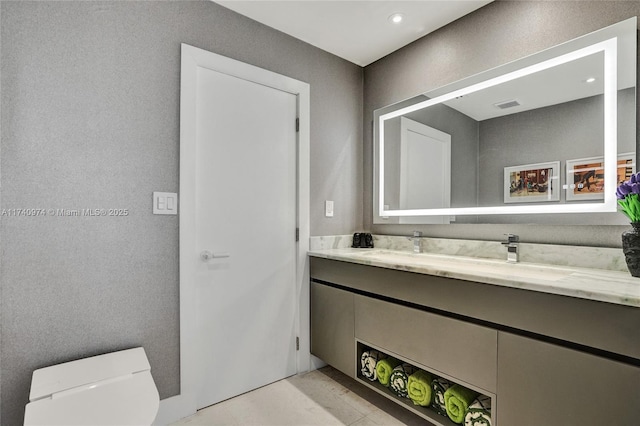 half bath with toilet, visible vents, and vanity