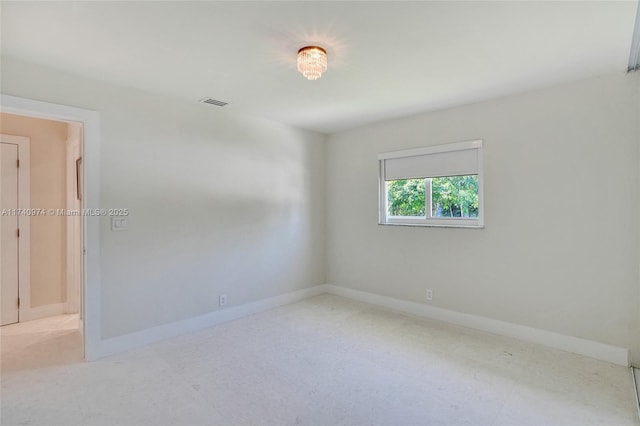 unfurnished room featuring baseboards and visible vents