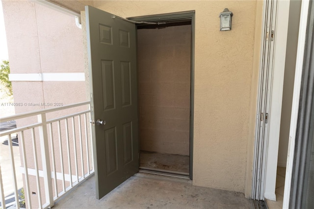 view of exterior entry with a balcony