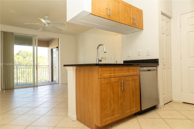 kitchen with light tile patterned flooring, sink, dark stone countertops, dishwasher, and ceiling fan