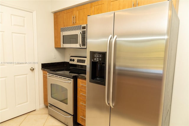 kitchen with light tile patterned flooring and appliances with stainless steel finishes