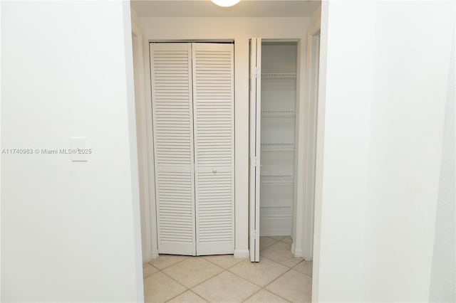 hall with light tile patterned floors