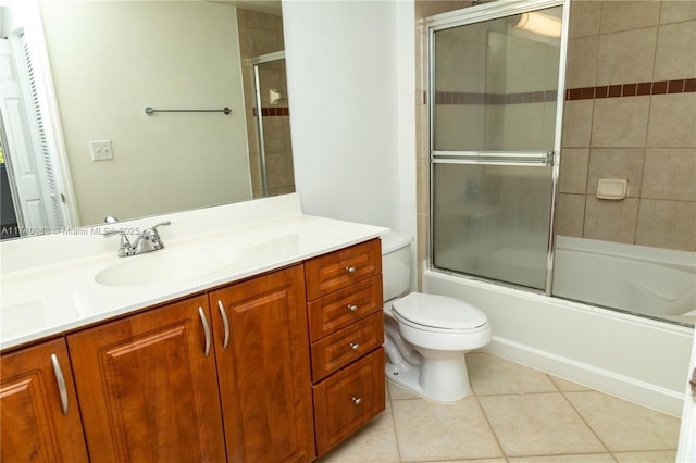 full bathroom featuring toilet, tile patterned floors, bath / shower combo with glass door, and vanity