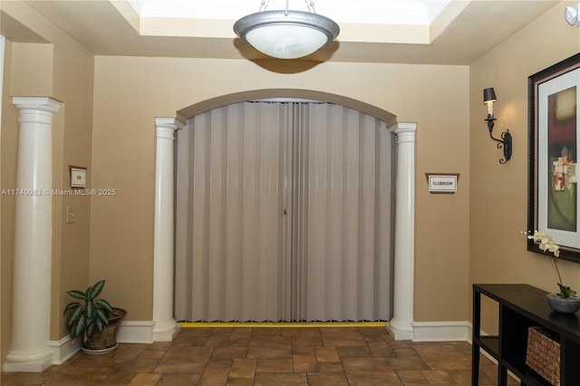 interior space featuring decorative columns, crown molding, and a tray ceiling