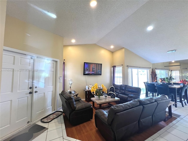 living area with lofted ceiling, plenty of natural light, and light tile patterned floors