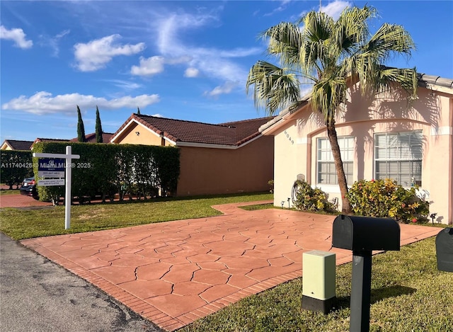 view of side of property with a tile roof and stucco siding