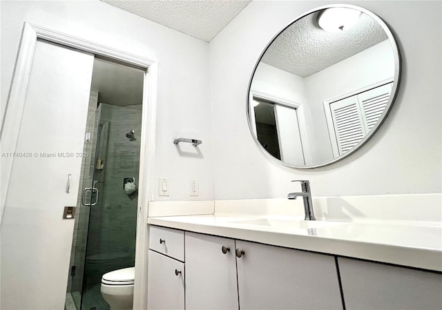 bathroom with vanity, an enclosed shower, a textured ceiling, and toilet