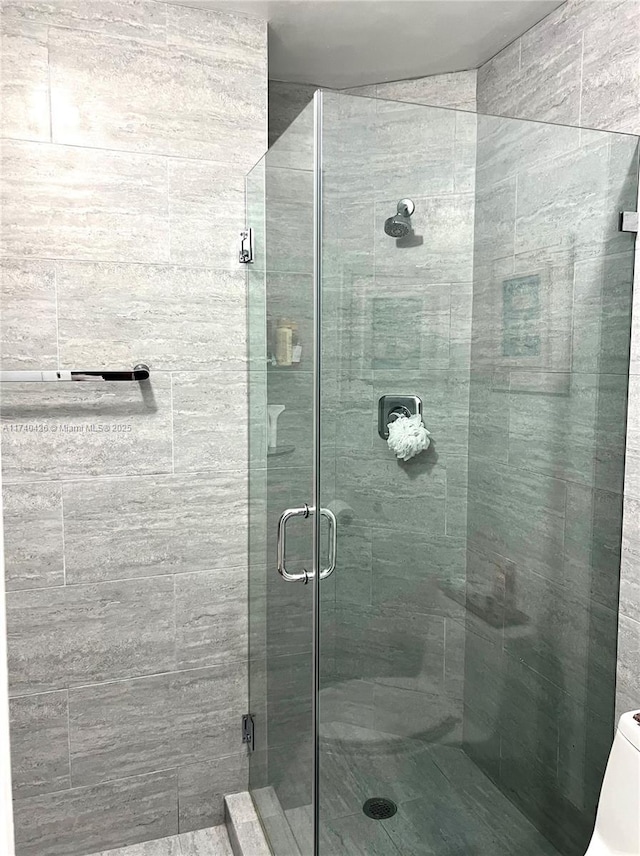 bathroom with walk in shower and toilet