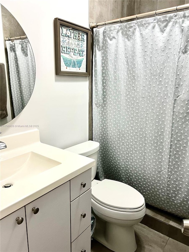 bathroom featuring walk in shower, vanity, and toilet