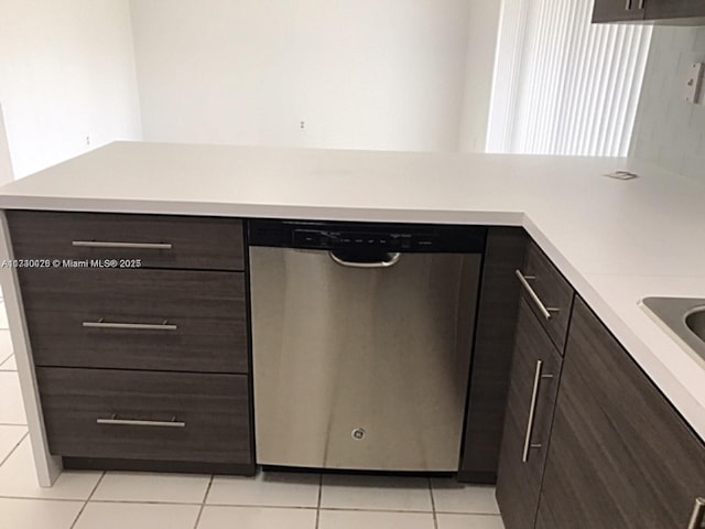 kitchen featuring light tile patterned floors, light countertops, stainless steel dishwasher, and dark brown cabinetry