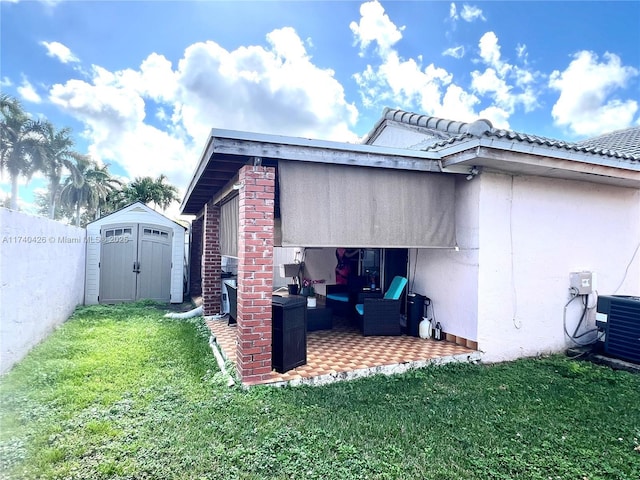 view of home's exterior with a storage shed, a yard, a patio, and an outbuilding