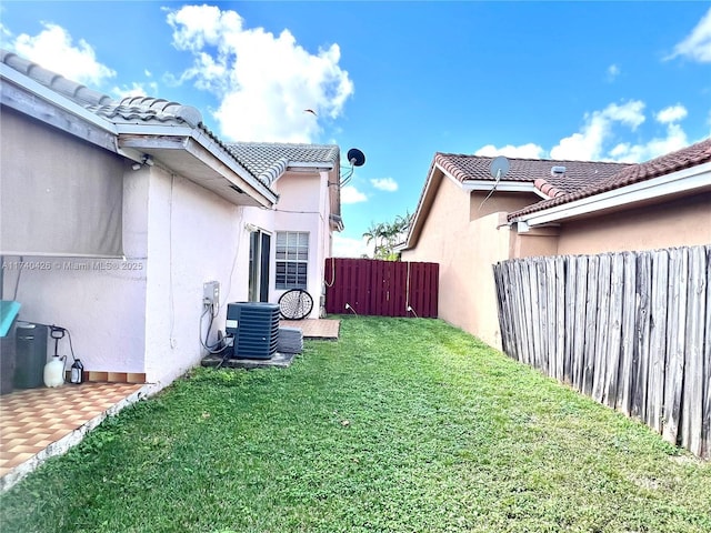 view of yard featuring fence and central air condition unit