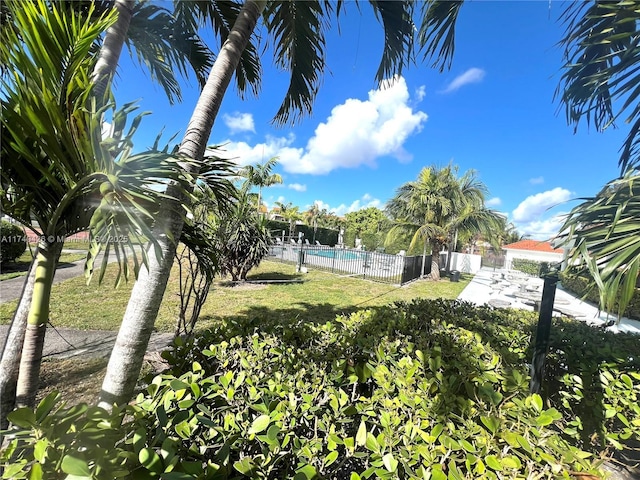 view of yard featuring fence and a community pool