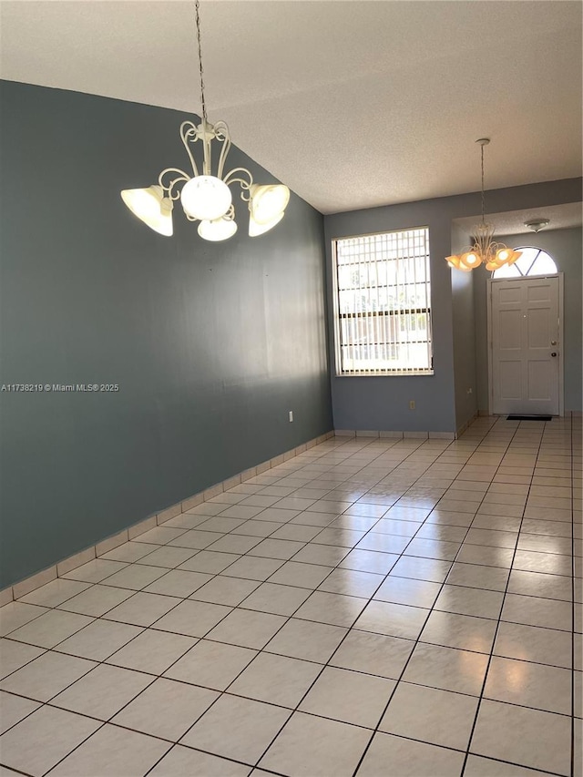 unfurnished dining area with light tile patterned floors, vaulted ceiling, and a chandelier