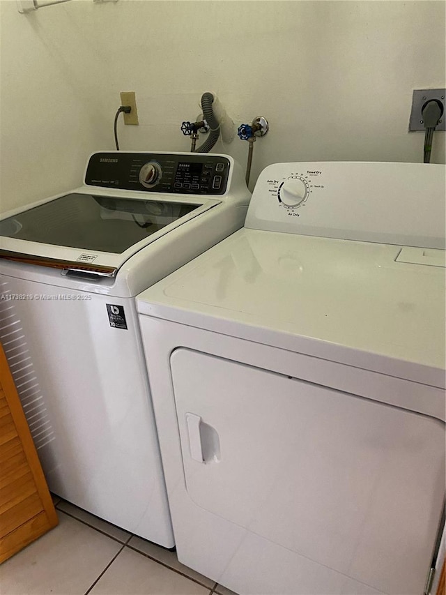 laundry area featuring light tile patterned flooring and independent washer and dryer