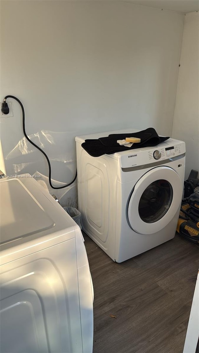 washroom with dark wood-type flooring and washer / dryer