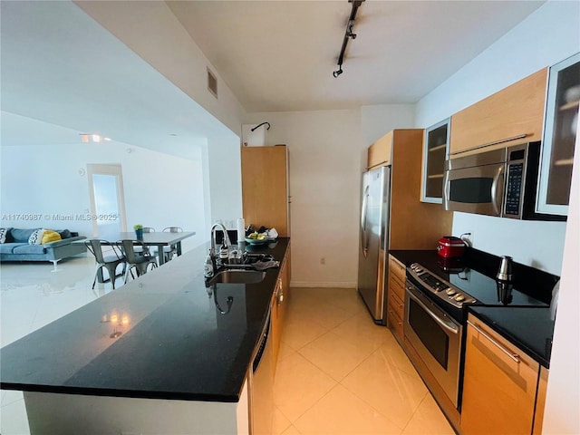 kitchen featuring sink, light tile patterned floors, rail lighting, and appliances with stainless steel finishes