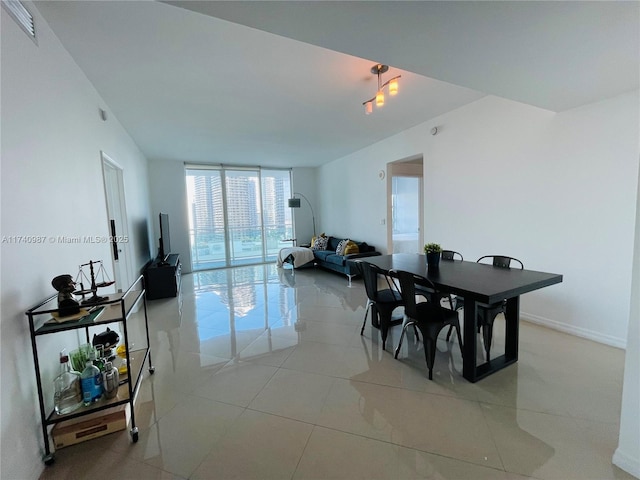 tiled dining space featuring a wall of windows