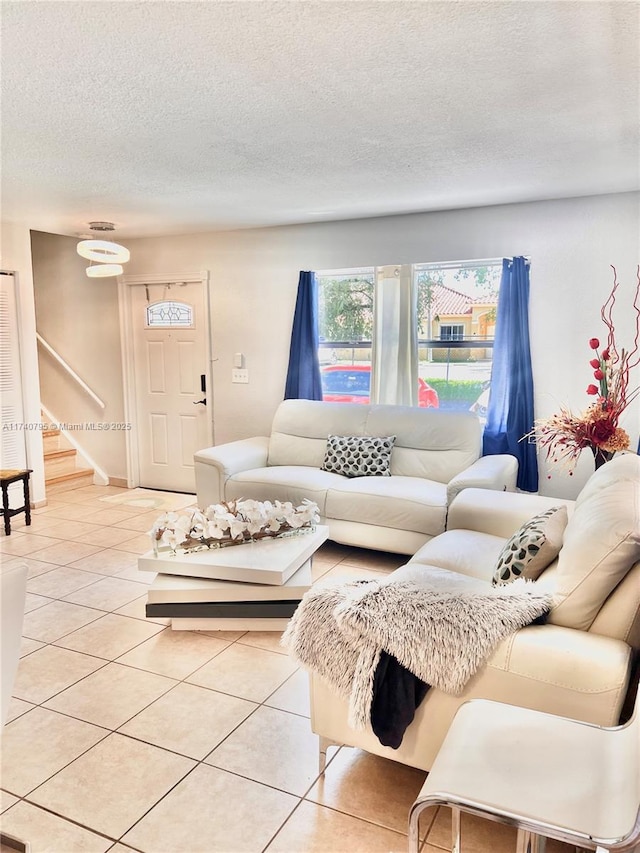 tiled living room featuring a textured ceiling