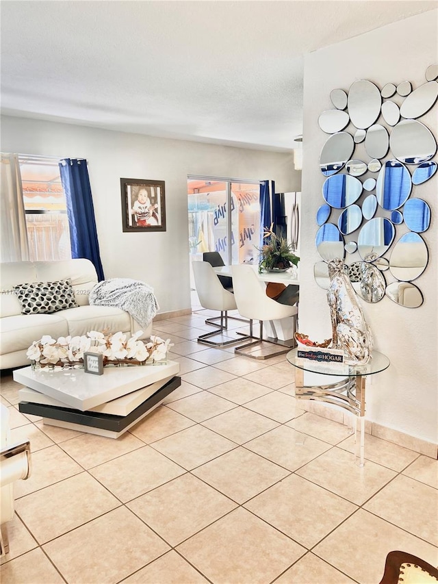 living room with a textured ceiling and light tile patterned flooring