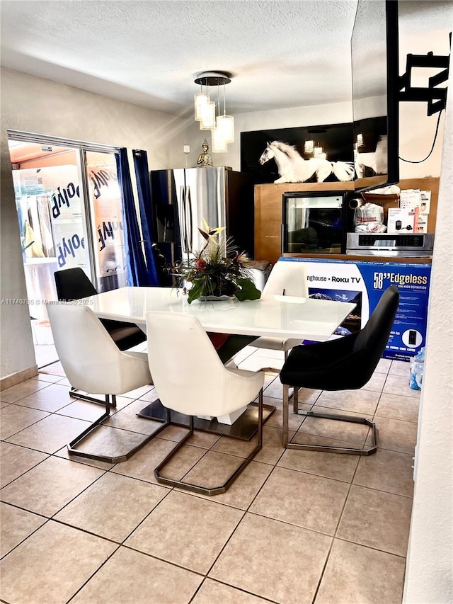 dining room featuring light tile patterned floors and a textured ceiling