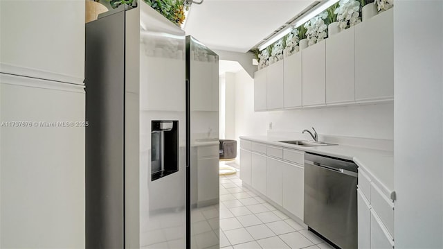 kitchen with white cabinetry, stainless steel appliances, sink, and light tile patterned floors